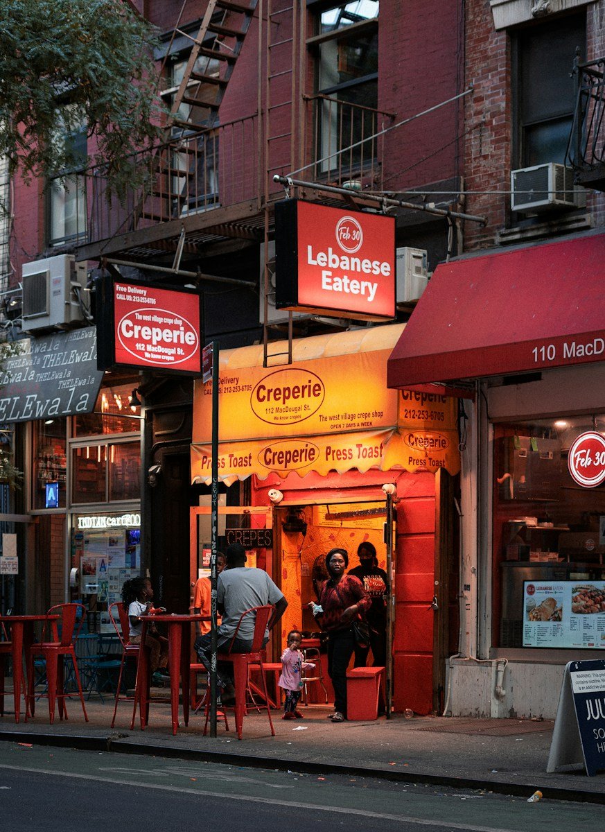 seo local para restaurantes en nueva york - people sitting on red chairs near store during daytime