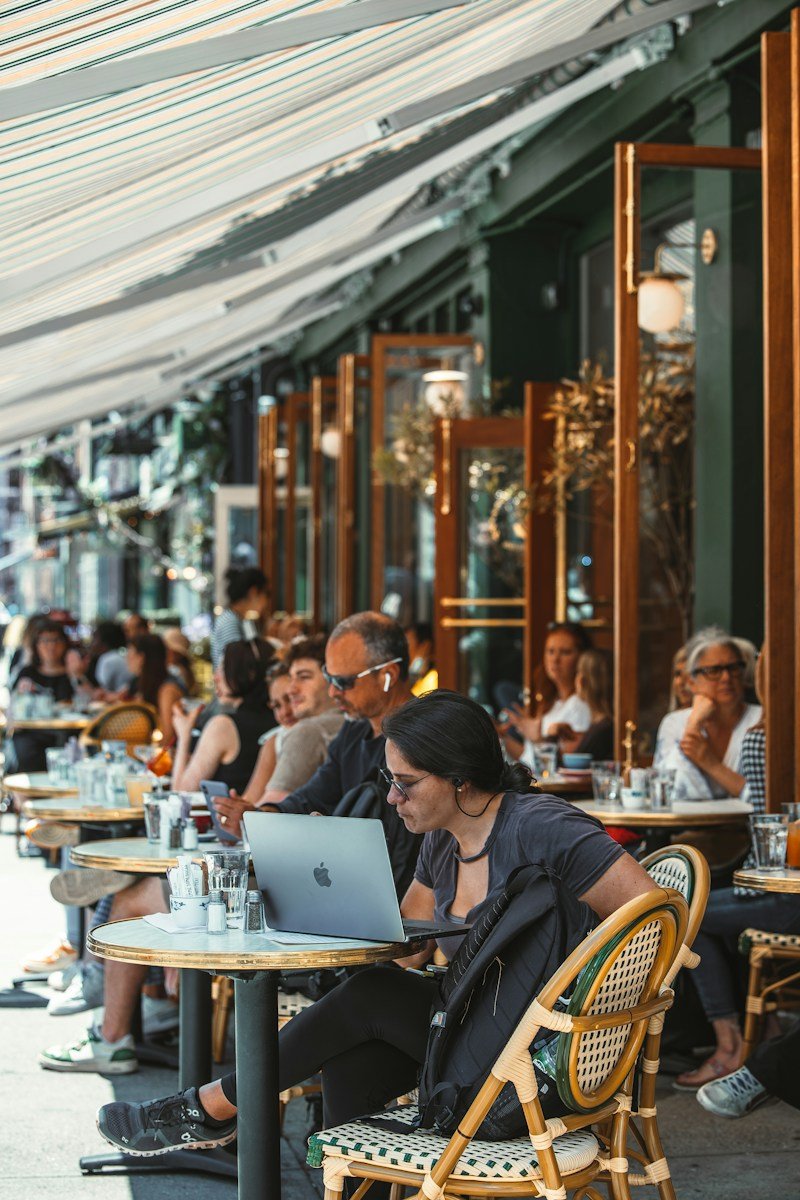 seo local para restaurantes en nueva york - people sitting at tables with a laptop