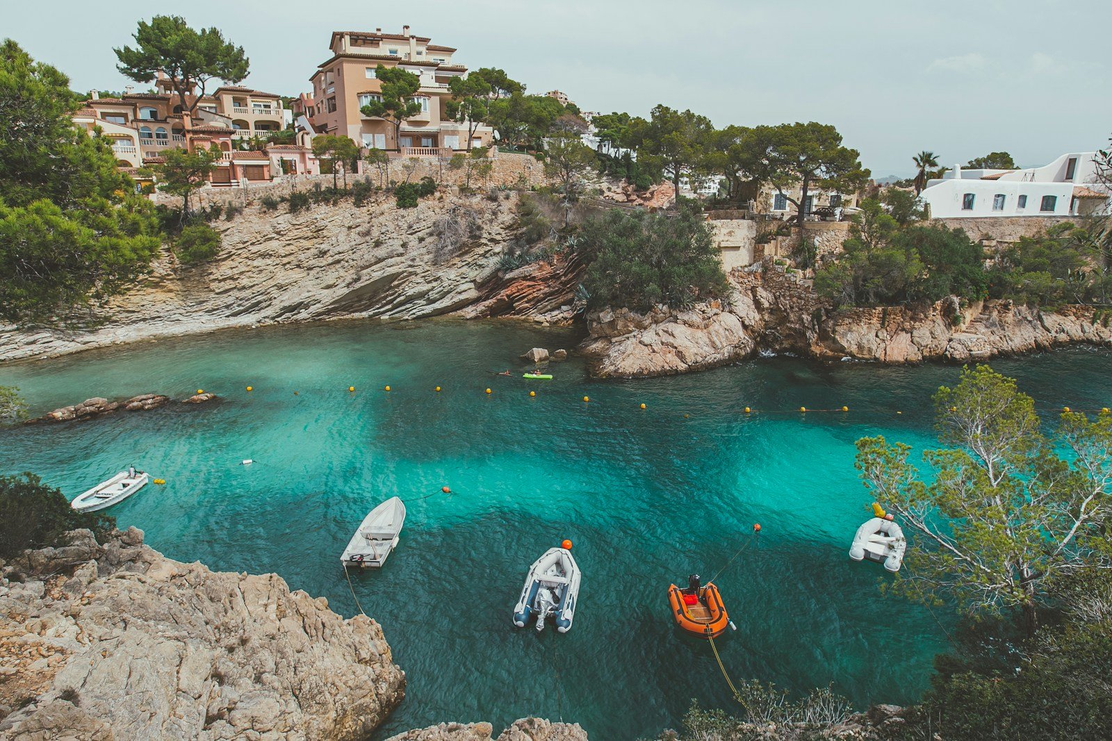 seo local para restaurantes en palma de mallorca - people in white and orange boat on water near brown rock formation during daytime